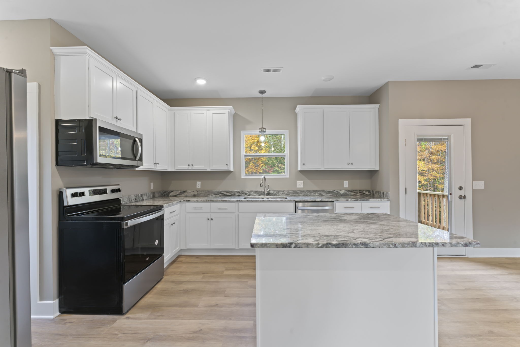 4357 Surji Circle Centerville, TN 37033 - Photo 10 of 25 a kitchen with stainless steel appliances granite countertop a stove top oven a sink a counter space and cabinets
