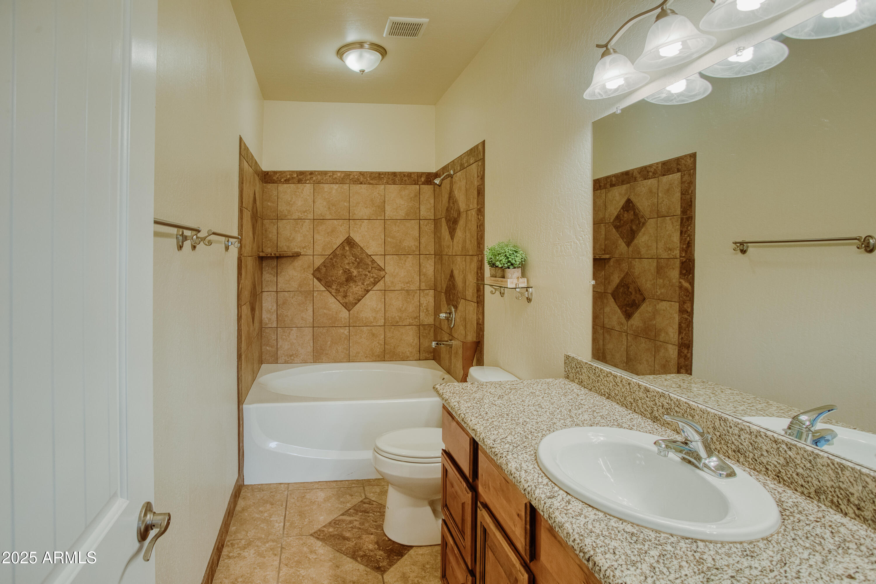 540 Rim Drive Show Low, AZ 85901 - Photo 10 of 35 a bathroom with a granite countertop sink a toilet a mirror a bathtub and shower