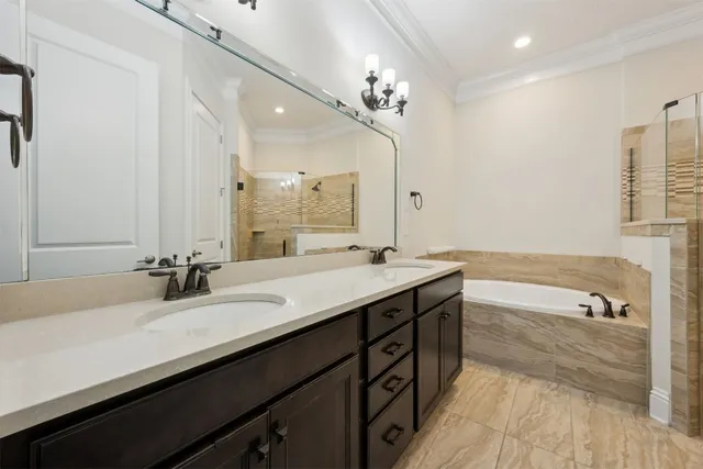 a bathroom with a double vanity sink a tub and a mirror