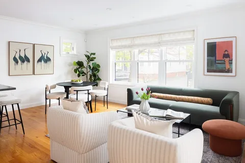 a living room with furniture and a large window with wooden floor