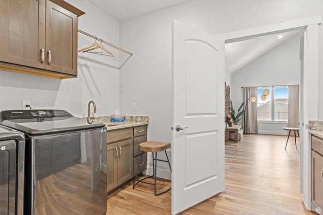 1343 North Trapper Loop Garden City, UT 84028 - Photo 23 of 56 Laundry room featuring cabinet space, light wood-style flooring, vaulted ceiling, and separate washer and dryer