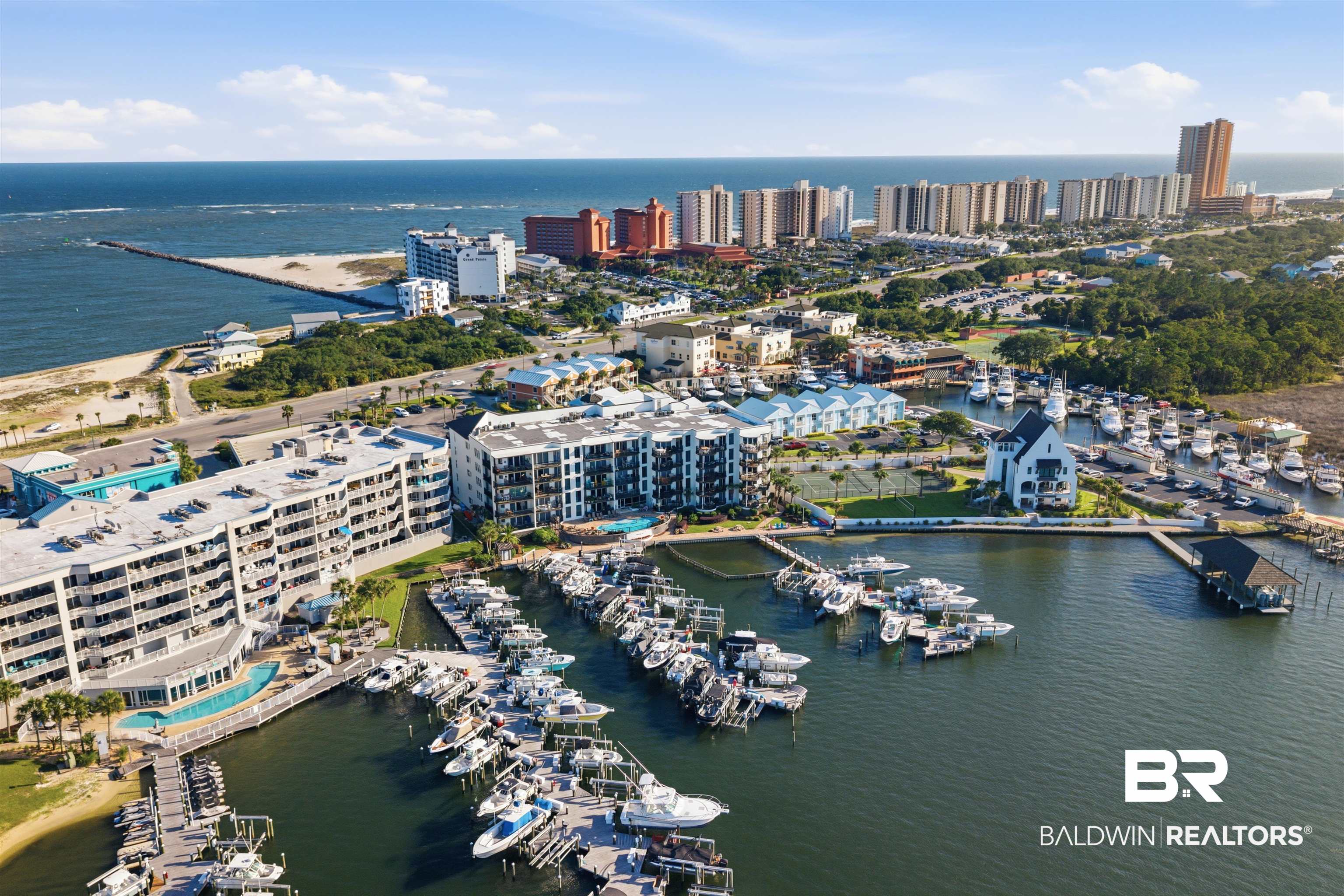 3564 Bayou Road, Unit 203 Orange Beach, AL 36561 - Photo 50 of 53 Marina with multiple boat slips, flanked by multi-story residential buildings featuring balconies