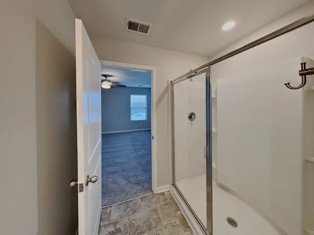 a bathroom with a shower and a glass door