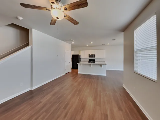 a view of kitchen with refrigerator stove and wooden floor