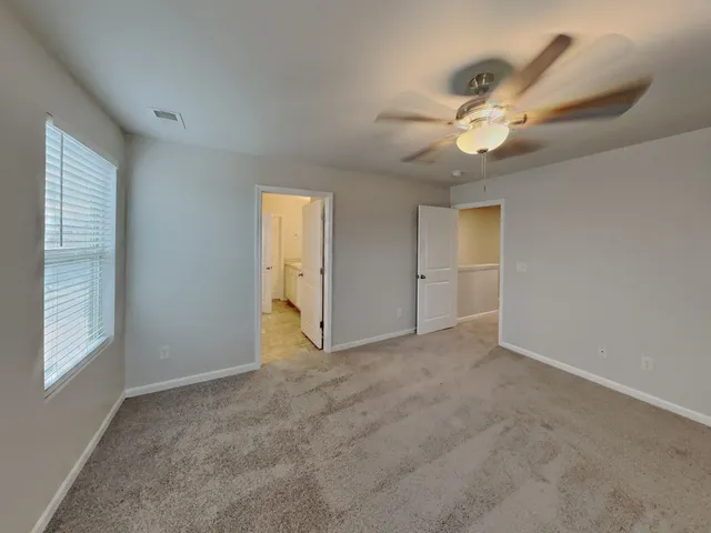 an empty room with fan and windows