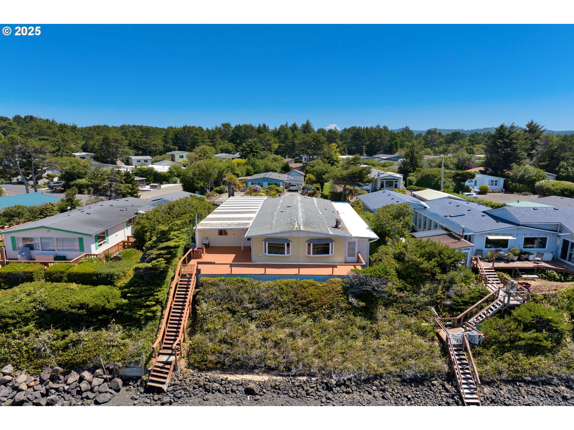 1601 Rhododendron Drive, Unit 610 Florence, OR 97439 - Photo 6 of 48 an aerial view of a house with a garden and trees
