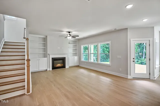 an empty room with windows and fireplace