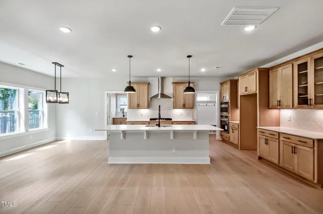a large kitchen with stainless steel appliances lots of counter space and a sink