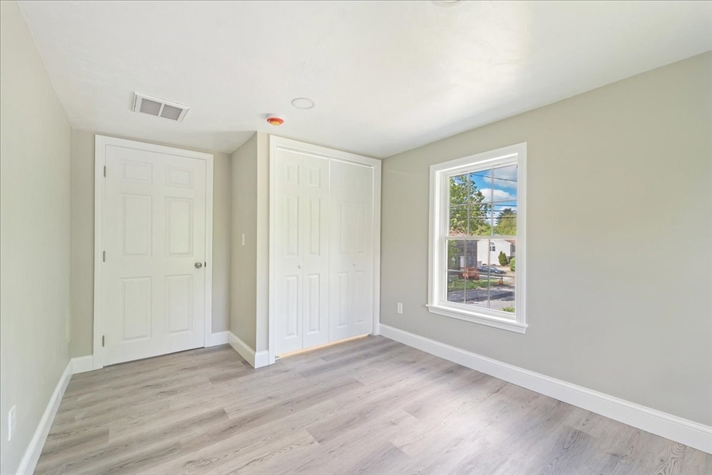 1009 Point Road Marion, MA 02738 - Photo 19 of 31 an empty room with wooden floor and windows