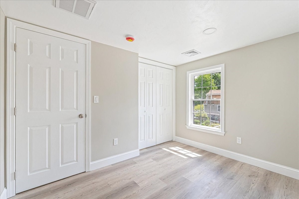 1009 Point Road Marion, MA 02738 - Photo 24 of 31 an empty room with wooden floor and windows