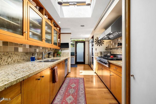 a large kitchen with stainless steel appliances granite countertop lots of counter top space and wooden floor