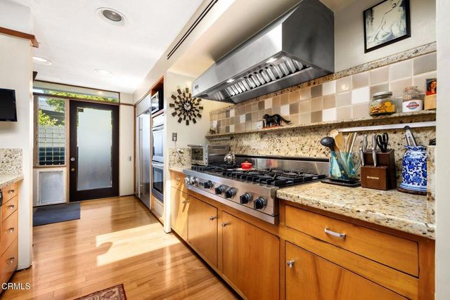 a kitchen with stainless steel appliances granite countertop a stove and cabinets