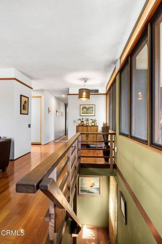 a view of a patio with couches table and chairs with potted plants and large tree