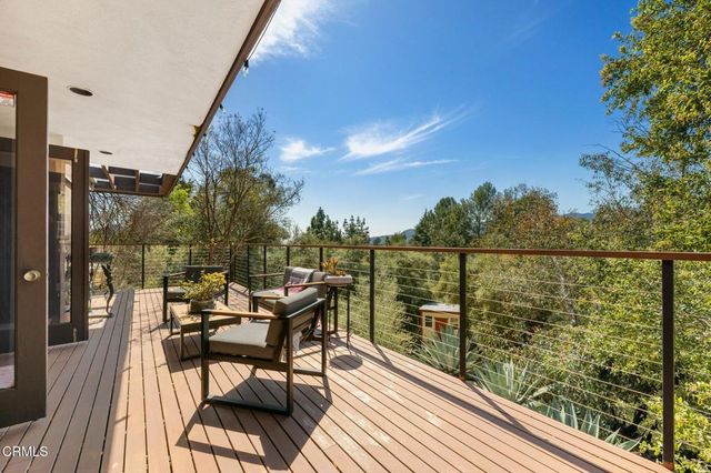 a view of a balcony with chairs and wooden floor