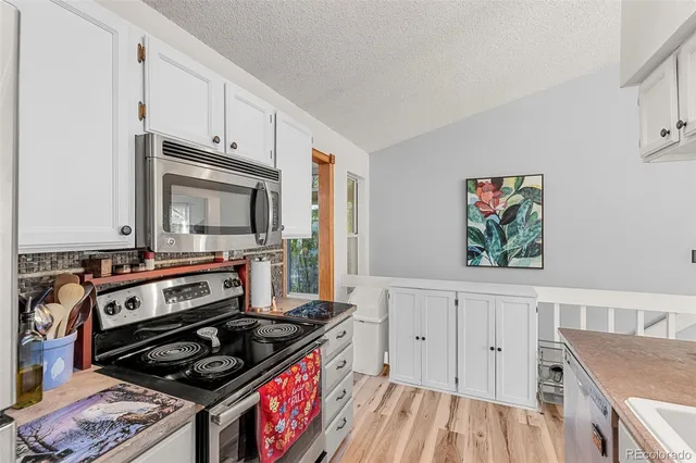 a kitchen with white cabinets and appliances