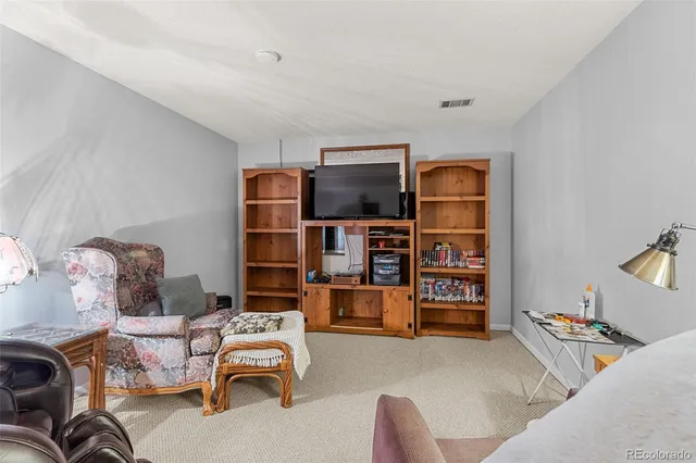 a living room with furniture and a bookshelf