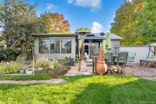 a view of a chair and table in backyard of the house