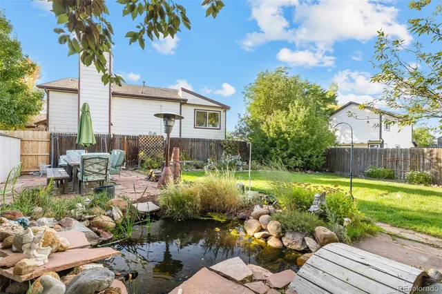 a backyard of a house with a garden and outdoor seating