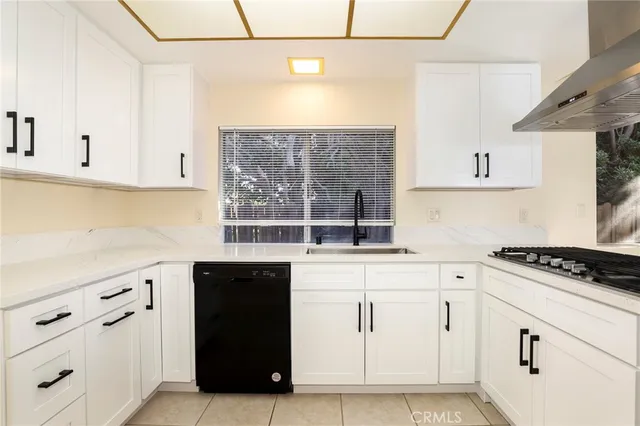 a kitchen with stainless steel appliances granite countertop a sink a stove and a refrigerator