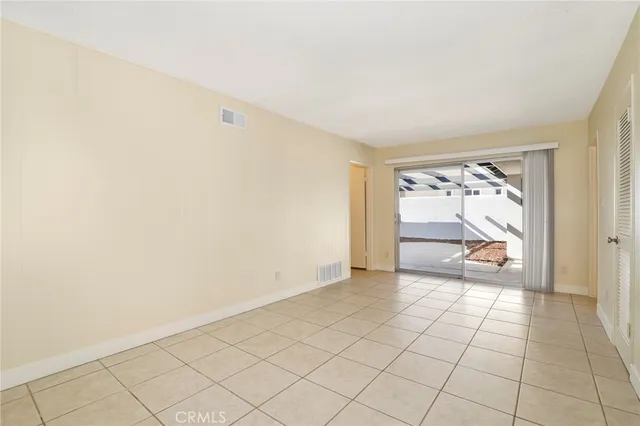 an empty room with a window and a ceiling fan