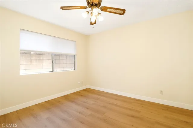an empty room with a window and a fan