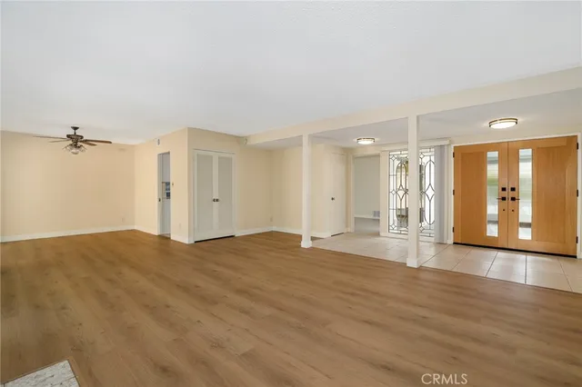 a view of an empty room with wooden floor fireplace and a window
