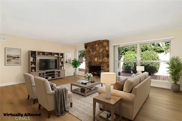a view of an empty room with wooden floor fireplace and a window