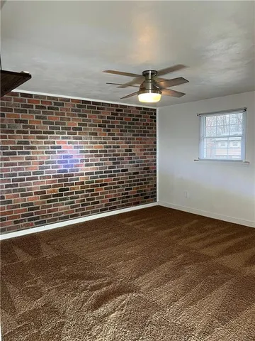 an empty room with a ceiling fan and window