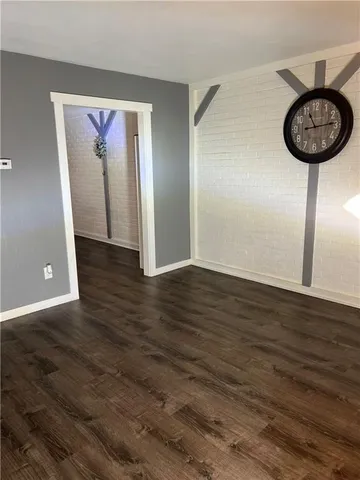 a view of a hallway with wooden floor and a chandelier