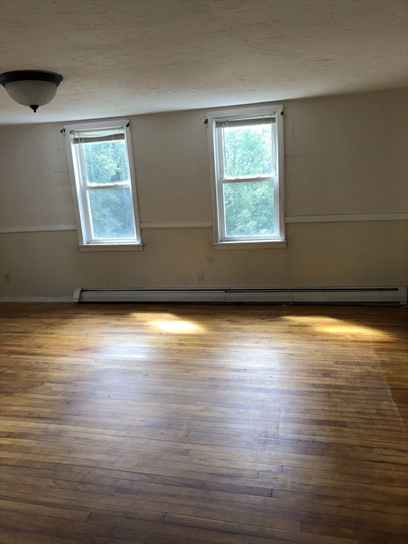 92-94 Sargent Street Leicester, MA 01611 - Photo 11 of 25 an empty room with wooden floor and windows