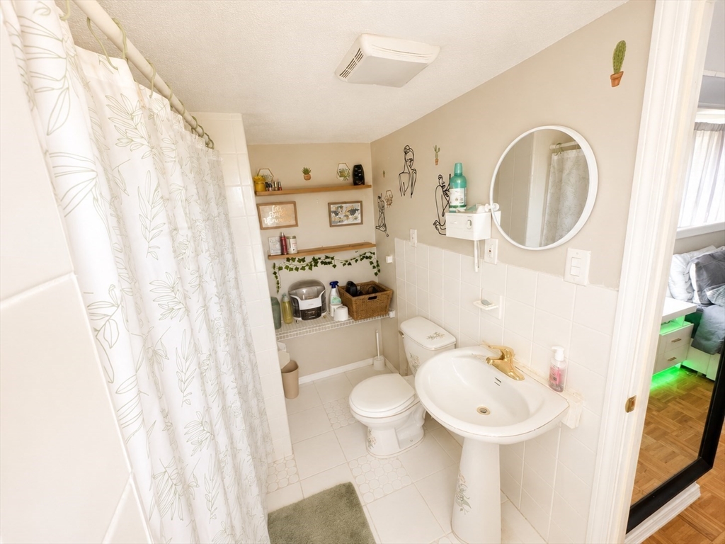 92-94 Sargent Street Leicester, MA 01611 - Photo 5 of 25 a bathroom with a sink a toilet and shower curtain