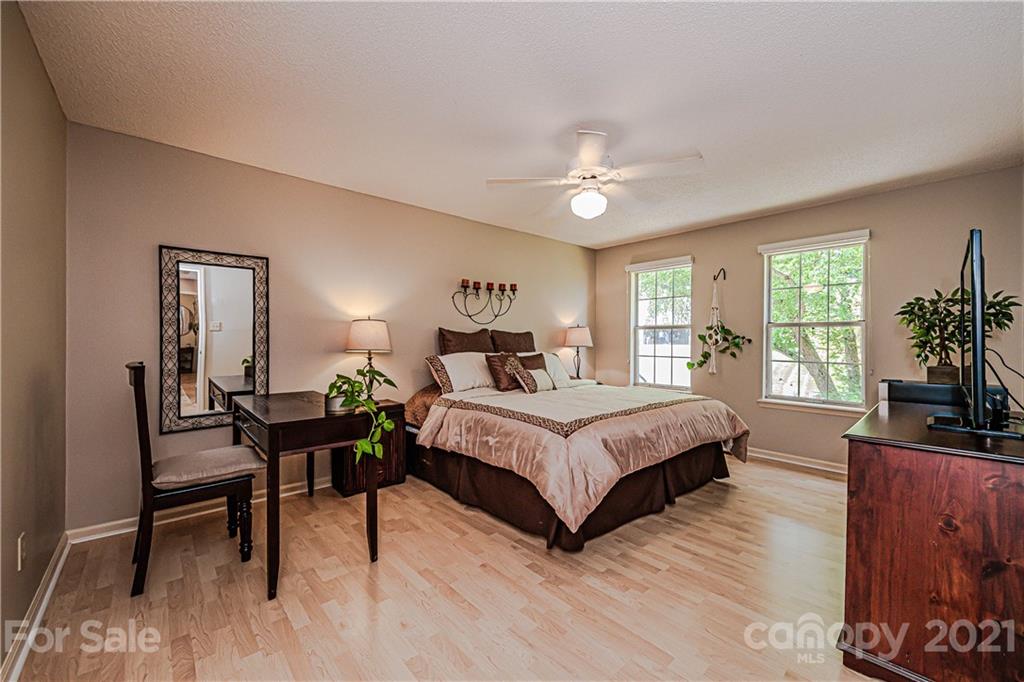 10722 Fairway Ridge Road Charlotte, NC 28277 - Photo 26 of 44 a spacious bedroom with a bed a bookshelf a desk and chair