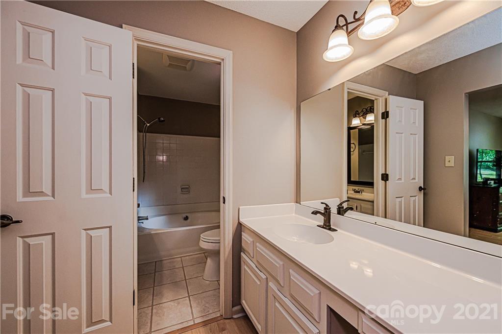 10722 Fairway Ridge Road Charlotte, NC 28277 - Photo 28 of 44 a spacious bathroom with a granite countertop sink and a mirror