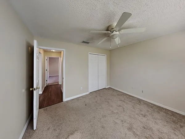 an empty room with a ceiling fan and a window