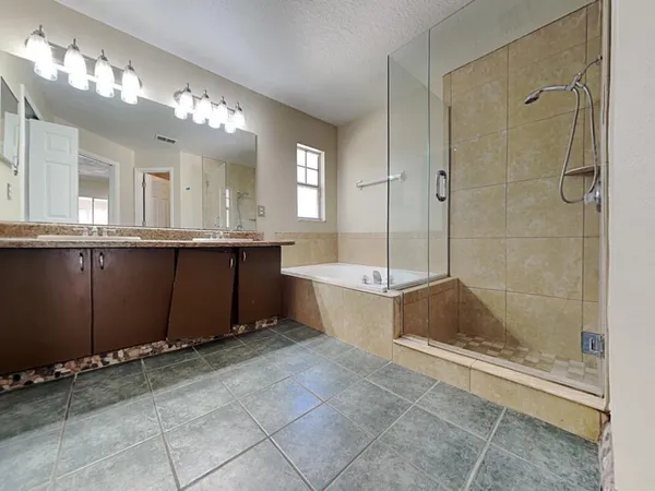a bathroom with a tub a sink and mirror