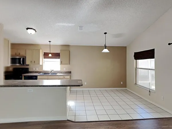 a view of a kitchen with kitchen island a sink stainless steel appliances and cabinets
