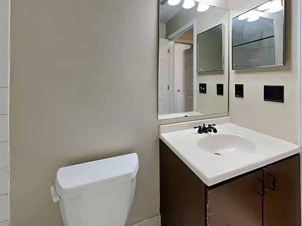 a bathroom with a sink toilet and mirror
