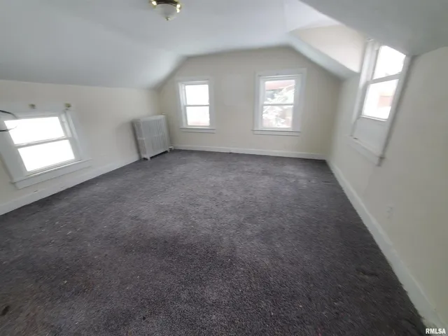 an empty room with windows and mirror in it