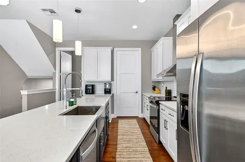 a kitchen with white cabinets and stainless steel appliances