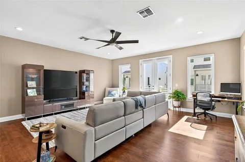 a living room with furniture flat screen tv and wooden floor