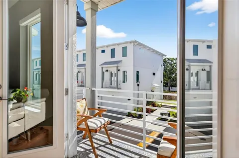 a view of balcony with two chairs and a potted plant