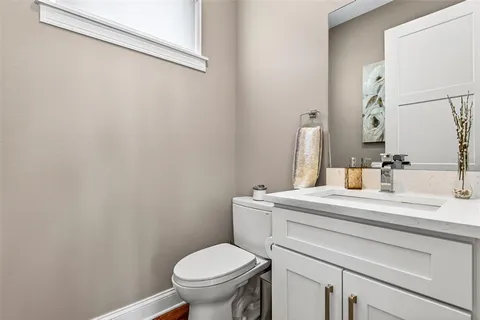 a bathroom with a sink mirror vanity and toilet