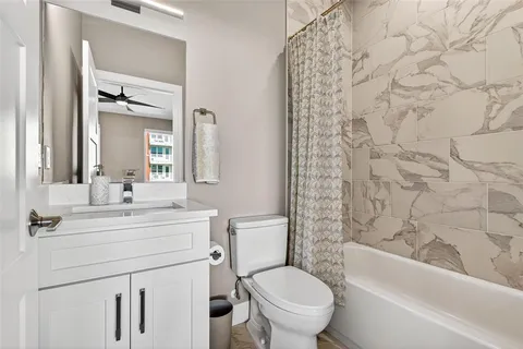 a bathroom with a sink toilet vanity and shower