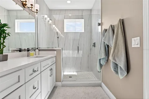 a bathroom with a double vanity sink a toilet and a shower