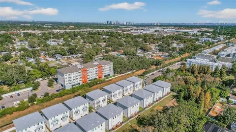 an aerial view of multiple houses with a yard