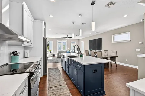 a large kitchen with kitchen island a sink a counter space and stainless steel appliances