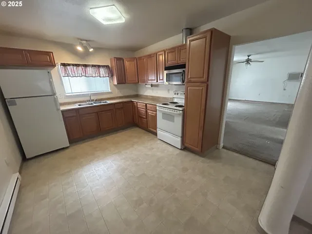 a kitchen with stainless steel appliances granite countertop a refrigerator a sink a stove a microwave a sink a refrigerator and cabinets