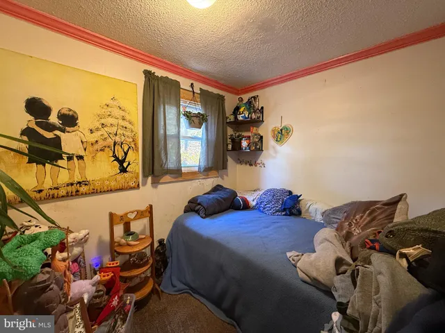 a bedroom with a bed and a painting on the wall