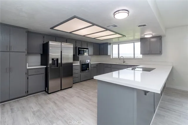 a kitchen with stainless steel appliances granite countertop a sink a refrigerator and a stove