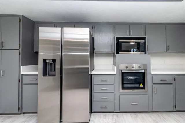 a kitchen with white cabinets and stainless steel appliances